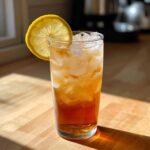 Glass of cold brew lemonade with ice and a lemon slice, perfect for a summer day. The best Cold Brew Lemonade!
