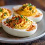 Close-up of beautifully presented deviled eggs, garnished with paprika and chives. Perfect for any occasion. These are deviled eggs.