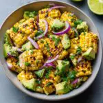 Overhead shot of a delicious Grilled Corn & Avocado Salad with red onion and cilantro.