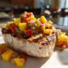 Close-up of grilled swordfish topped with vibrant mango salsa, a delicious dish.