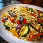 Close-up of a plate of Lemon Herb Orzo with Grilled Vegetables, including zucchini, peppers, and eggplant.