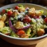 Close-up of a delicious Olive Garden Salad with croutons, tomatoes, olives, and cheese.