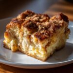 A close-up of a slice of Overnight French Toast Casserole on a white plate.