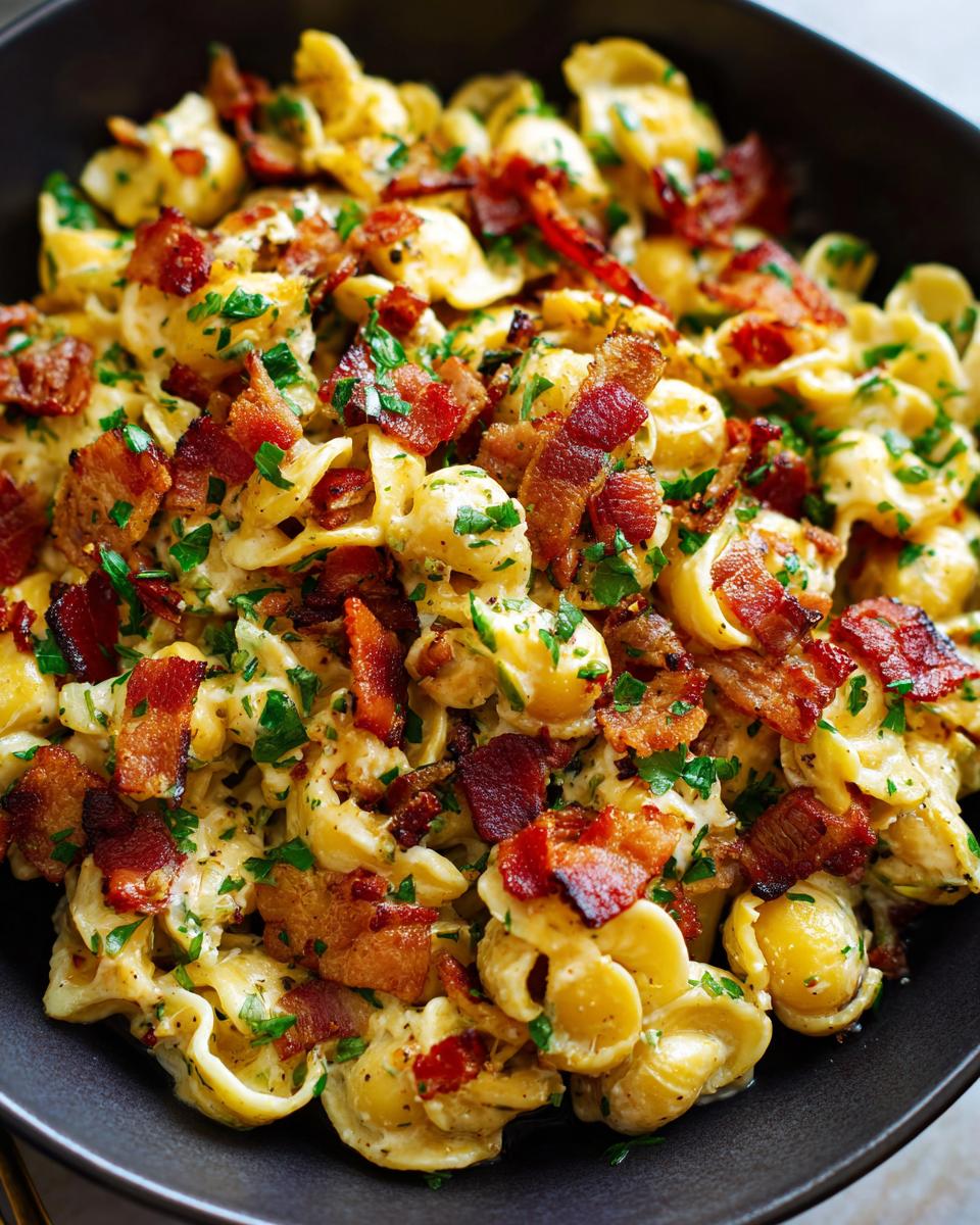 Close-up of pasta salad bacon with creamy sauce and fresh parsley.