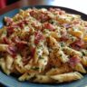 Close-up of a creamy pasta salad with bacon, herbs and cheese.