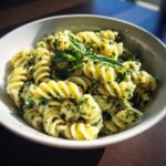 Amazing pasta salad basil: 30 mins 11 Close-up of pasta salad basil with fresh basil leaves in a white bowl.