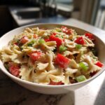 Amazing Pasta Salad Bowtie: 1 Hour Chill 11 Bowl of delicious pasta salad bowtie with tomatoes, green onions, and creamy dressing. The pasta salad bowtie is ready to eat.