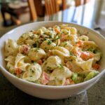 A bowl of creamy pasta salad classic with shell pasta, vegetables, and herbs.