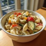 A bowl of delicious pasta salad classic with shell pasta, colorful vegetables, and creamy dressing.