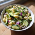 Amazing Pasta Salad Cucumber: 1 Cool Bite 11 Close-up of a bowl of pasta salad cucumber with fresh dill and red onion.