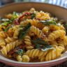 Close-up of pasta salad with dressing, basil, and sun-dried tomatoes. Perfect pasta salad dressing recipe.