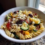 Amazing Pasta Salad Greek: 5 Flavor Secrets 11 Close-up of a bowl filled with Greek pasta salad, featuring pasta, vegetables, feta, and olives. This is a pasta salad greek.