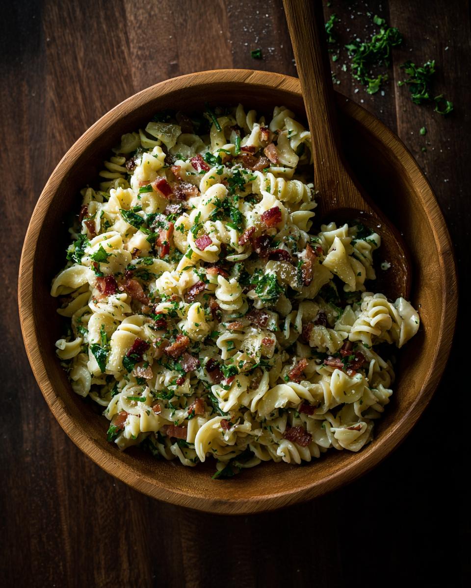 Amazing pasta salad spring: 30 minute delight 5 Overhead shot of creamy pasta salad spring with bacon and fresh herbs in a wooden bowl.