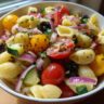 Pasta salad with shell pasta, tomatoes, cucumbers, olives and red onion. How do you make pasta salad?