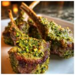 Close-up of perfectly cooked Pistachio Crusted Lamb Chops on a white plate.