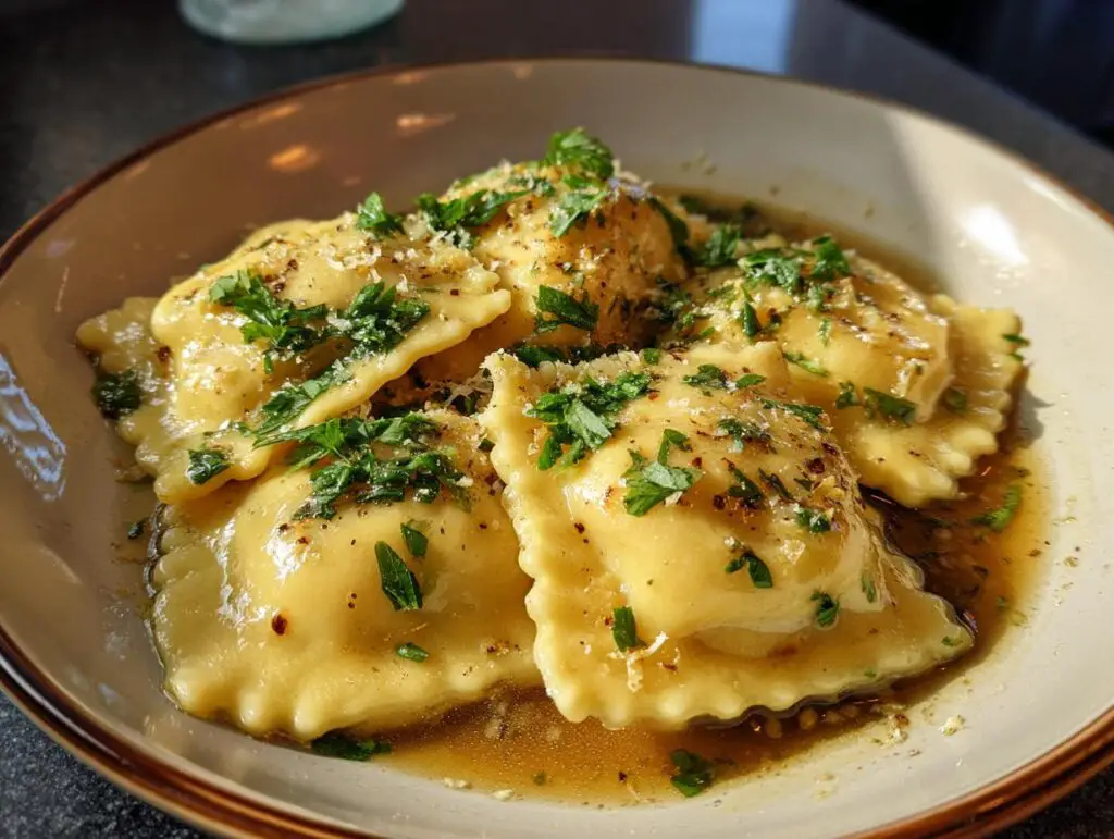 Close-up of Ricotta & Lemon Ravioli with Brown Butter, garnished with herbs and parmesan cheese.