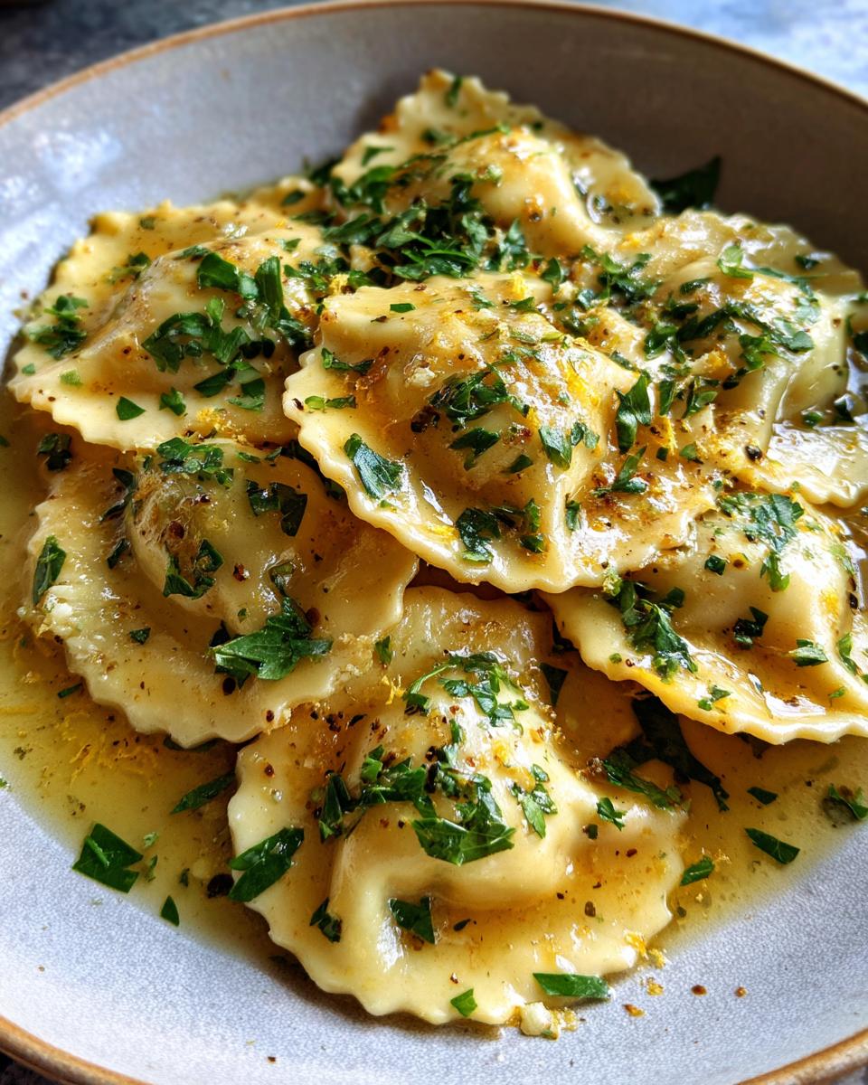 Close-up of Ricotta & Lemon Ravioli with brown butter sauce and fresh herbs.