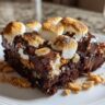Close-up of a slice of S'mores Brownie Bars with toasted marshmallows and chocolate.