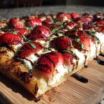 Close-up of a slice of Strawberry Balsamic Flatbread with fresh strawberries and balsamic glaze.