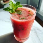 Glass of refreshing Watermelon Mint Agua Fresca garnished with fresh mint leaves.