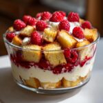 Close-up of a layered White Chocolate Raspberry Trifle with fresh raspberries and cake.